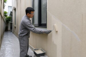 Thợ xử lý vết nứt và lăn lớp phủ chống thấm cho tường ngoài nhà